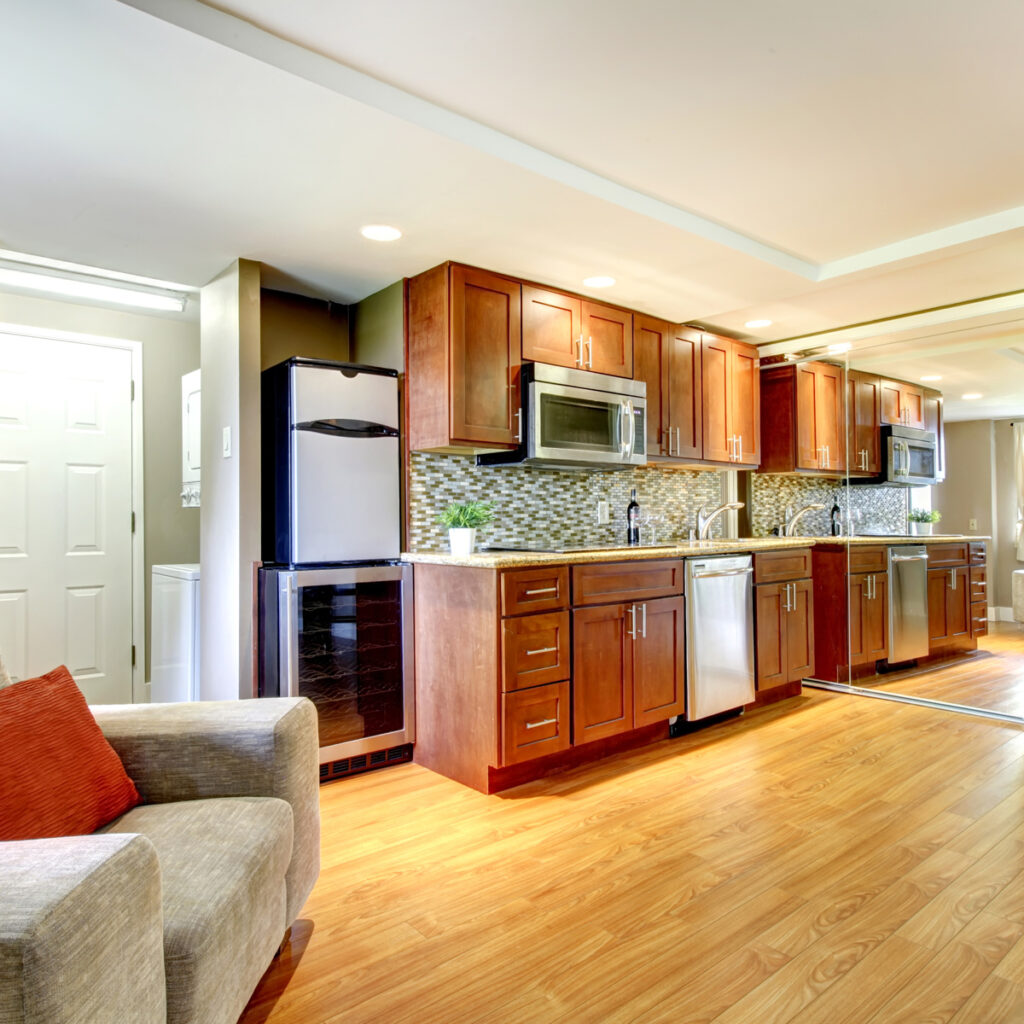 Luxurious basement kitchen in a modern apartment, featuring hardwood floors and sleek design.