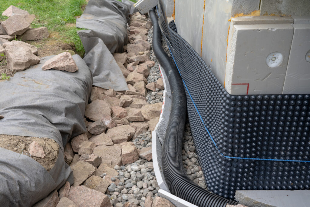 Water drainage pipe system around a house foundation for efficient water flow