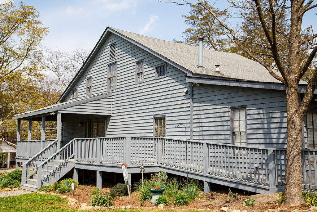 Gray two-story house with a handicap-accessible ramp on the front porch.