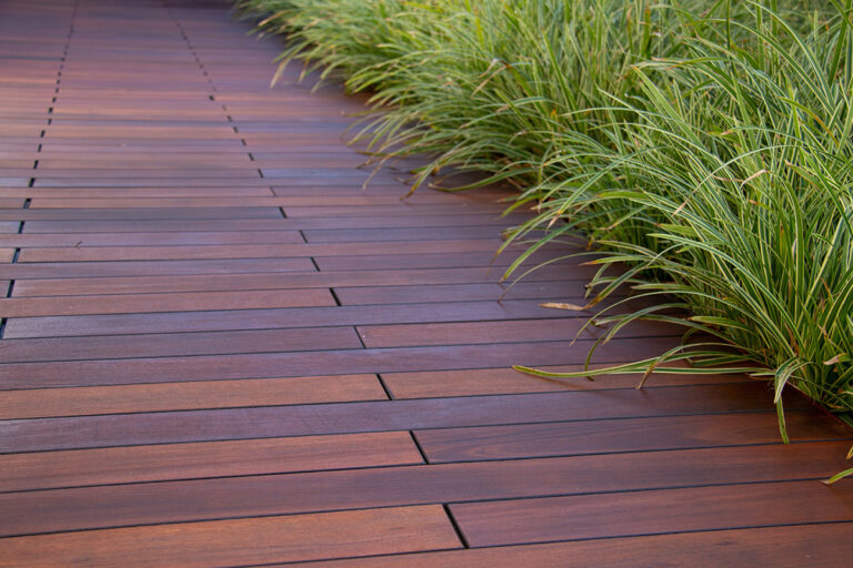 Beautiful hardwood deck with lush green landscaping, highlighting natural elegance.