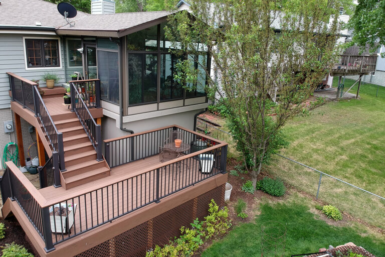 Pressure treated decks with natural brown stain, steps leading to a screen room.