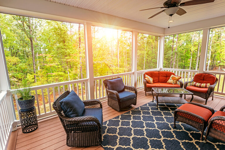 Screened-in porch adorned with fall foliage.
