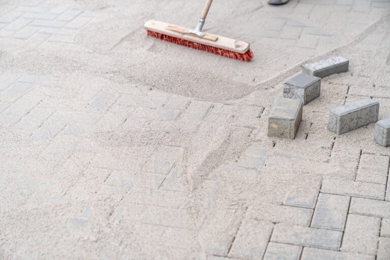 sweeping sand with a broom during the construction of a new pavement